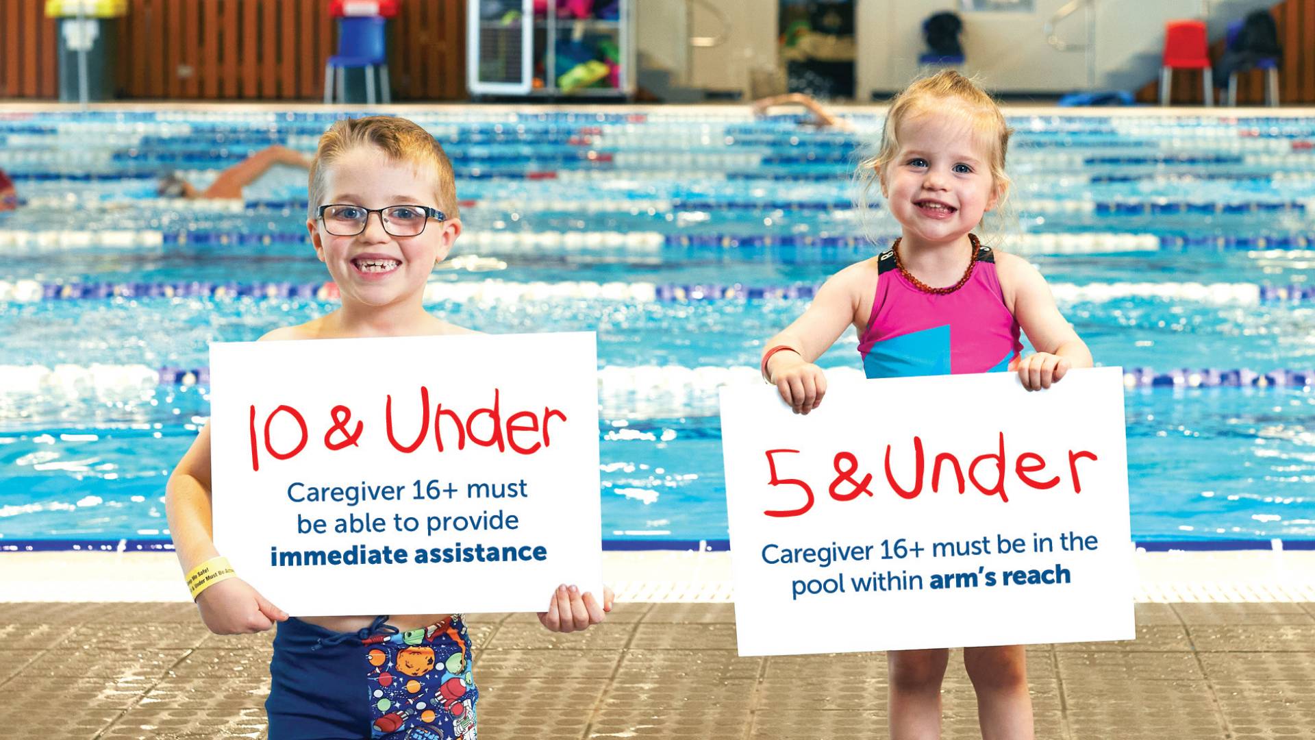 Children poolside holding signs that outline the Bay Venues supervision policy for children 10 & under